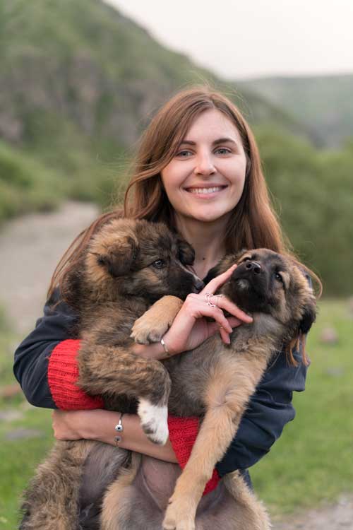 Woman-Smiling-While-Holding-Brown-and-Black-German-Shepherd
